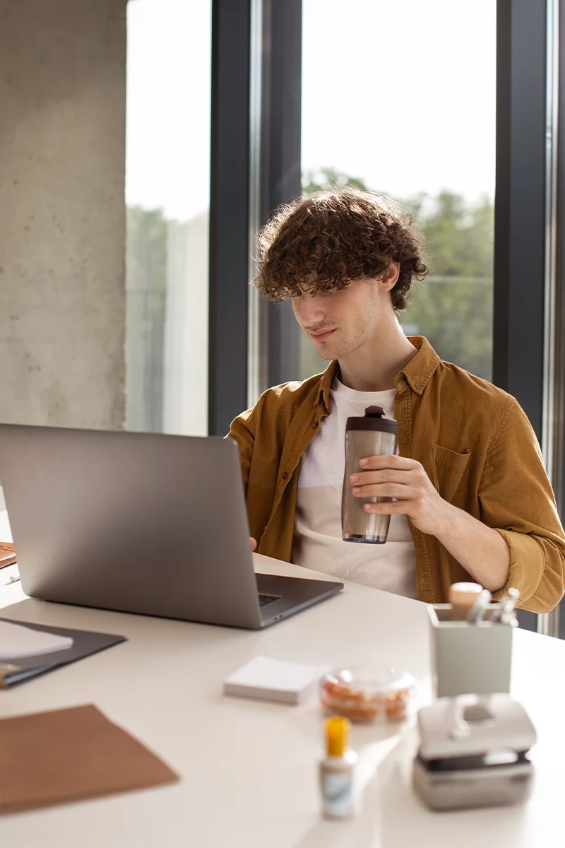 Joven estudiando con los cursos online de la academia de oposiciones SKR desde su portátil.