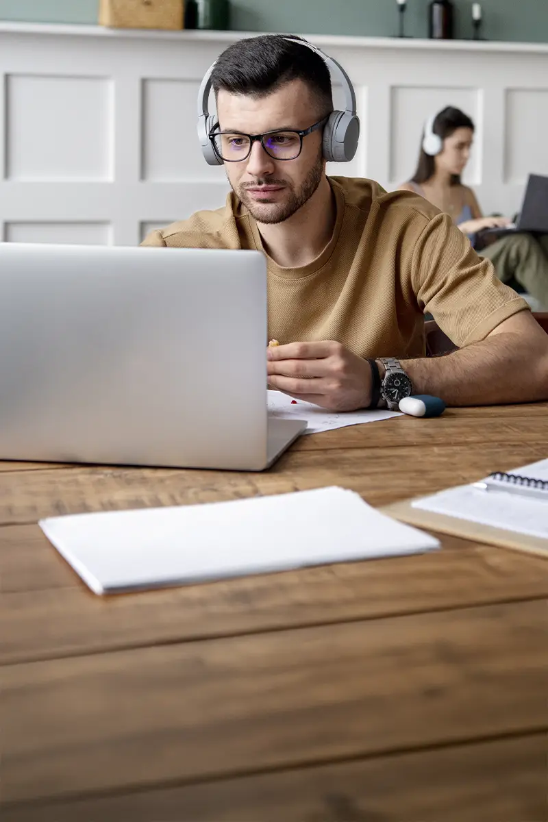 Alumno con auriculares cursando un posgrado online en la academia de oposiciones SKR.